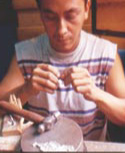 A Salvadoran man makes a wooden craft